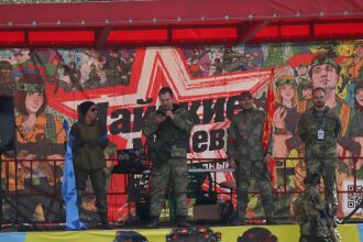 Команда LASERWAR на фоне яркого баннера мероприятия
